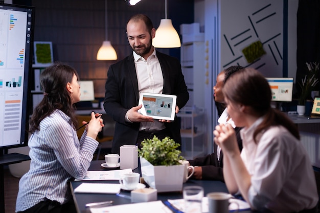 Entrepreneur businessman presenting company strategy on tablet during meeting.